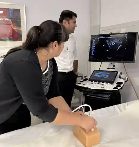 Demonstrating the technique of fine needle aspiration on a training model.