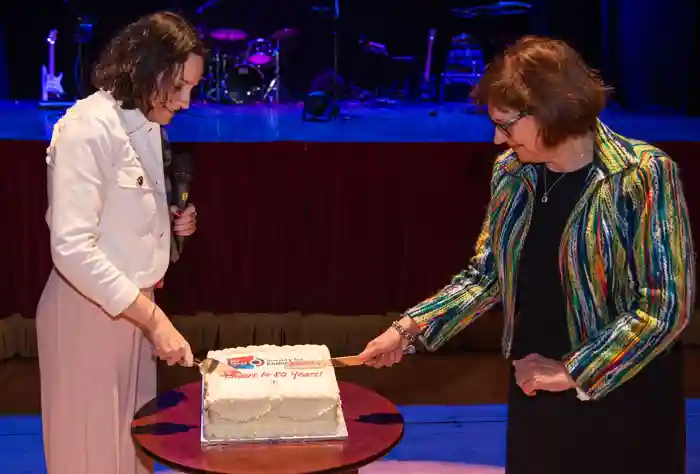 Márta (right) cutting the SfE 80th Anniversary cake with Kristien Boelaert.